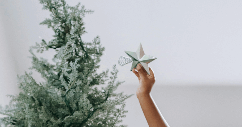 image - My Teen Mental Health Holiday teen depression support: Child places star on Christmas tree, offering hope and family connection during the holidays.